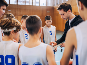 A basketball coach speaks to his players