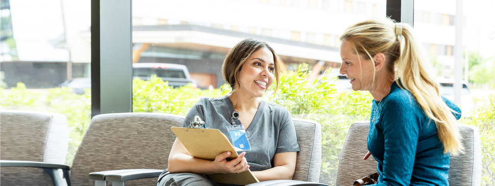 Female clinical researcher looking in microscope.