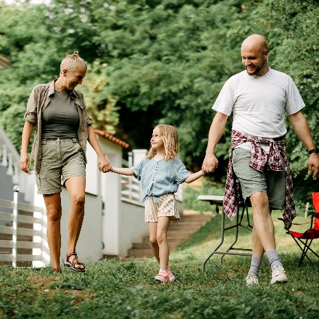 Family walk together through rural neighborhood garden
