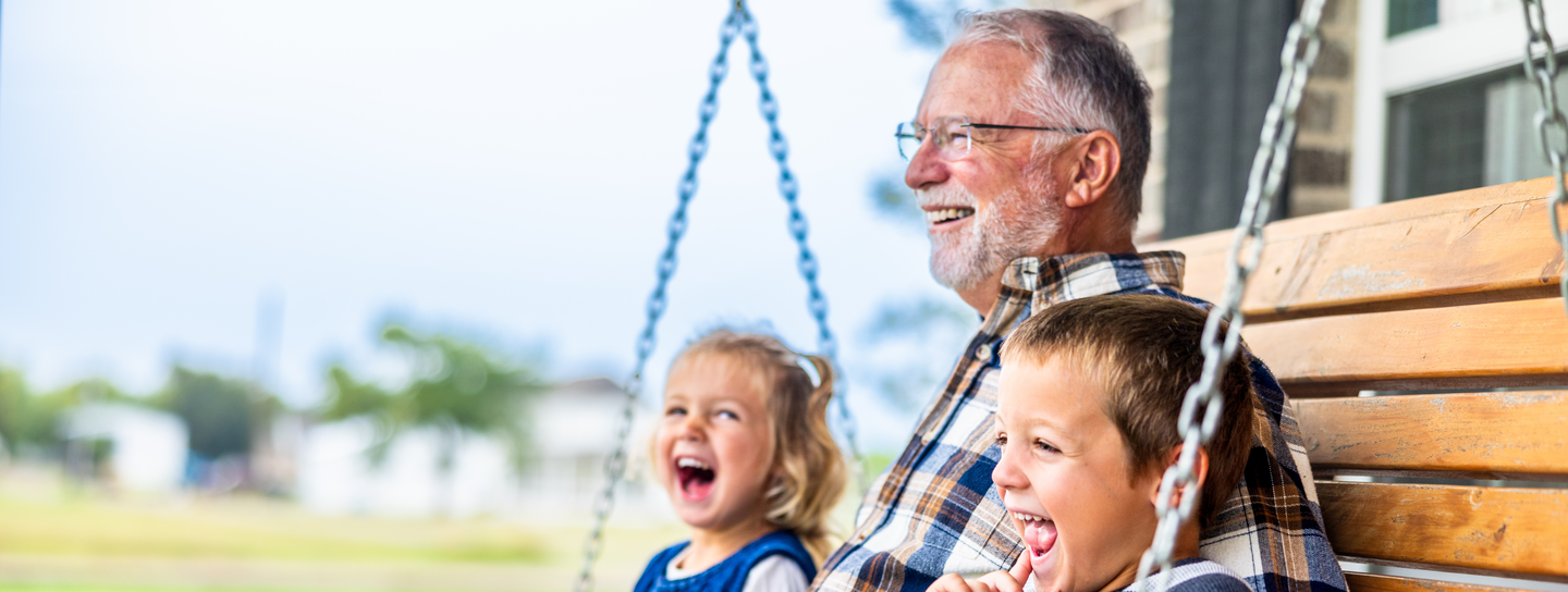 Grandpa on a porch swing with grandkids