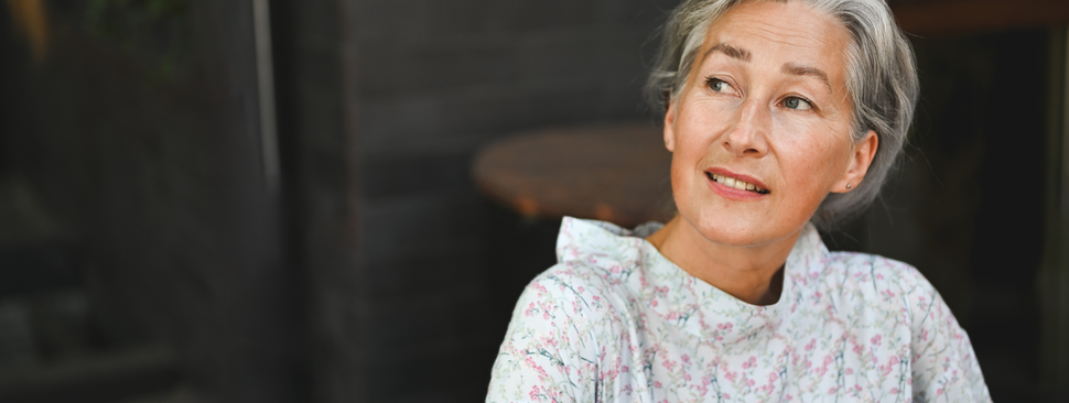 A mature woman looks off into the distance