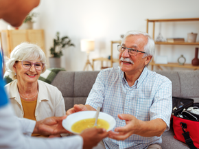 nurse bringing hot soup plate at home