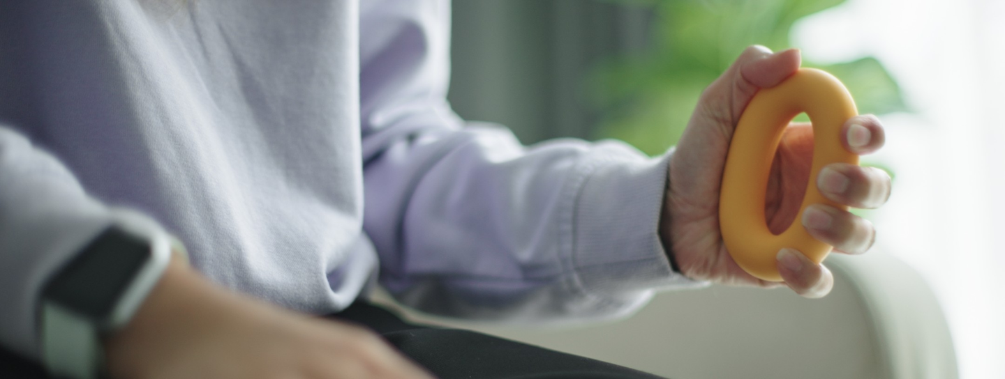 A person uses a therapy tool to practice their grip strength