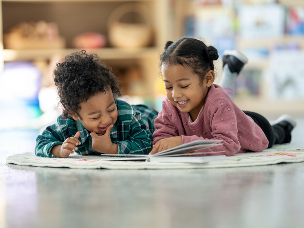 Kids reading book on floor