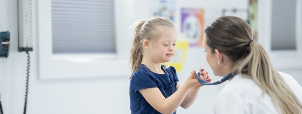 A child being examined by a doctor with a stethoscope.