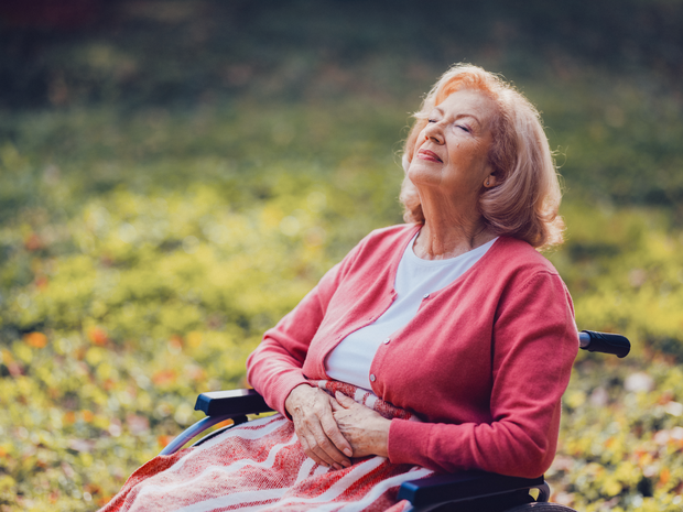 Elderly woman enjoys fresh air outside.