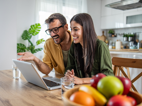 Pregnant woman and partner speak to provider on a laptop from their home.