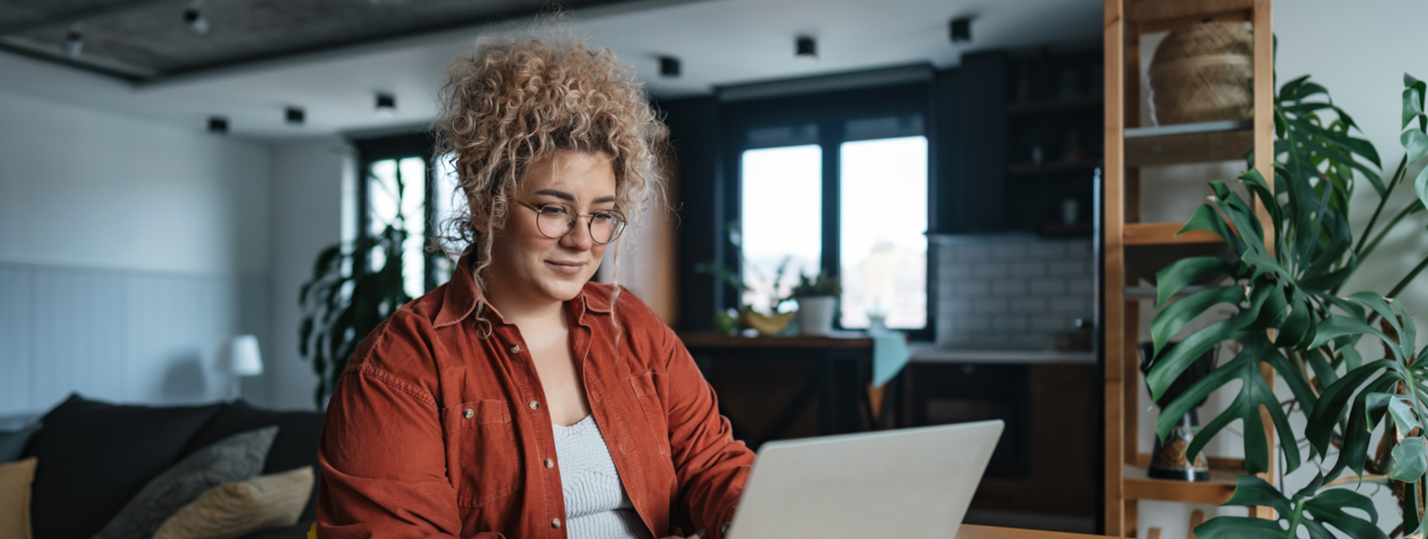 Group sitting around a table, listening to someone speak.