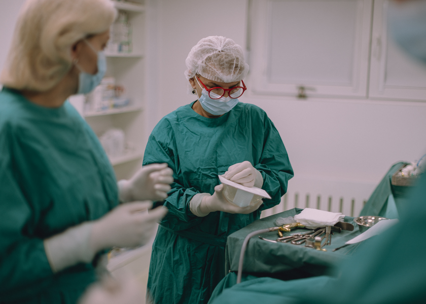Surgeons preparing tp perform breast reconstruction surgery in operating theatre.
