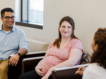 pregnant woman and partner meet with health care provider