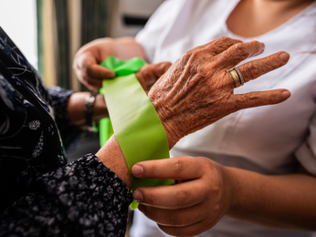 Older woman's hand with athletic tape.