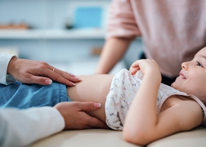 Pediatrician Examining a Smiling Child in the Doctor's Office
