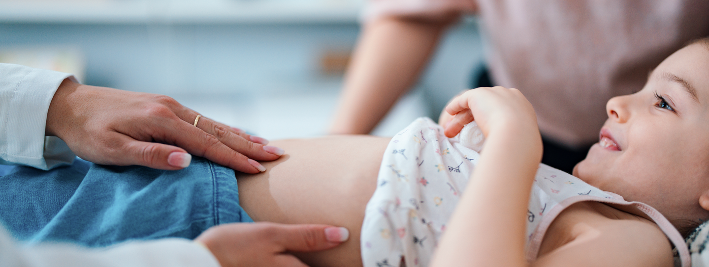 Pediatrician Examining a Smiling Child in the Doctor's Office