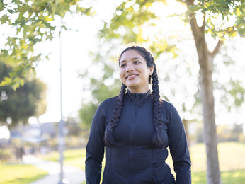 Woman smiling while walking outdoors.