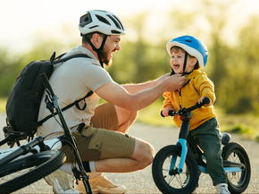 dad fixes child's bike helmet