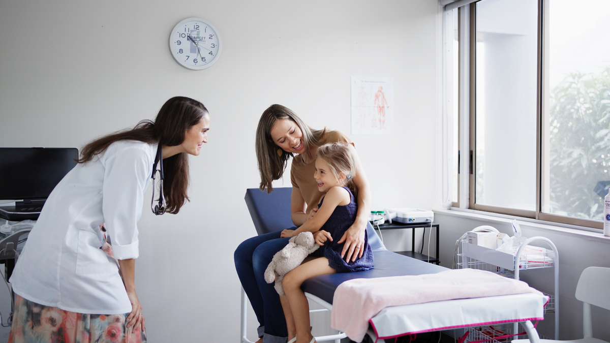 Provider in clinic with a mother and her young daughter