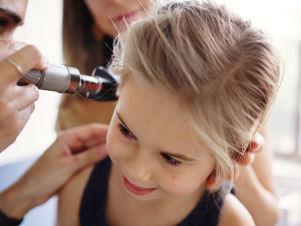 A St. Luke’s provider performs an ear exam on a young patient.