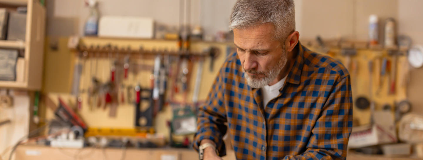 Mature man works in the woodshop