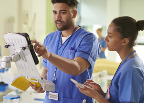 Student nurse with his mentor on the meds trolley