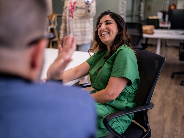 Woman provider laughs while working in hospital.
