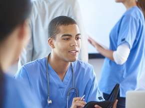 Male nurse taking notes.