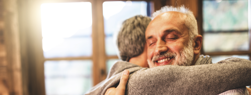 Two men embrace with a smile