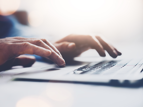 Person types on laptop keyboard.