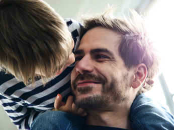 Child sitting on father's shoulders