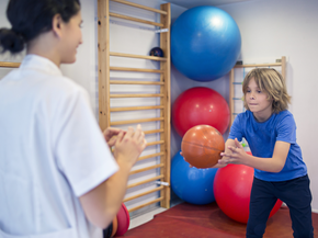 Child doing rehabilitation exercises with physical therapist