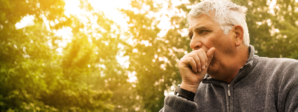 A man covering his mouth while he coughs
