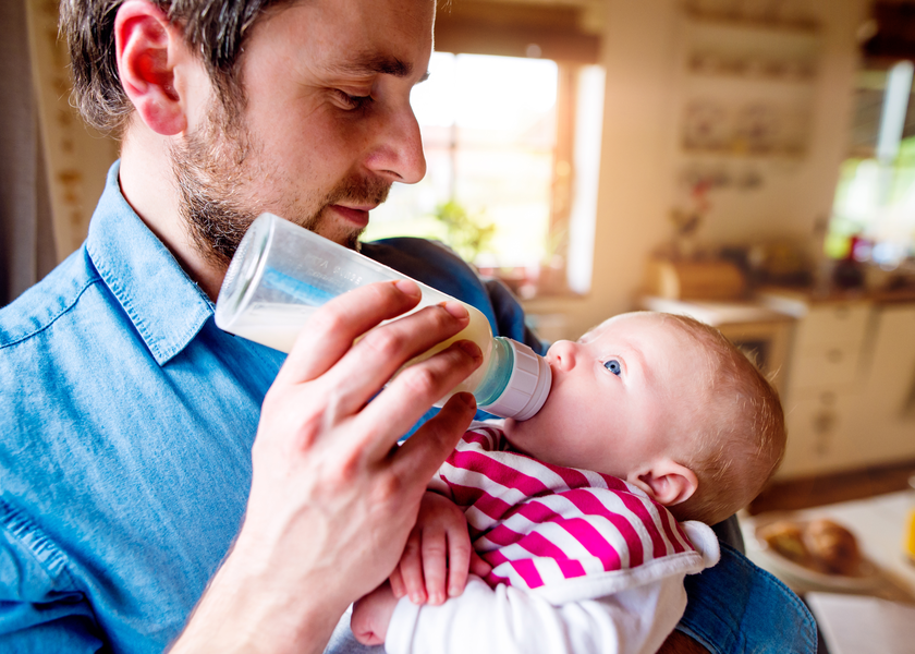 A father feeds his baby with a bottle