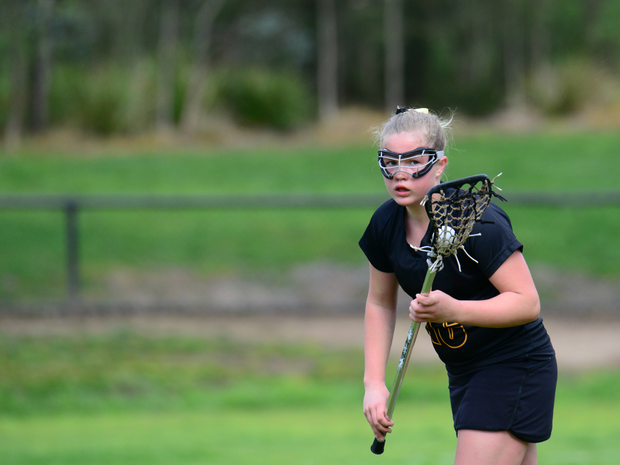 Teen girl playing lacrosse
