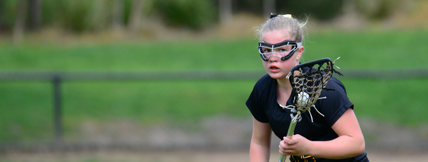 Teen girl playing lacrosse
