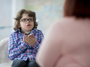 Young girl with disabilities communicates with a caregiver