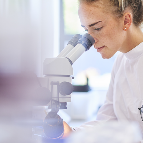 Woman looking through microscope