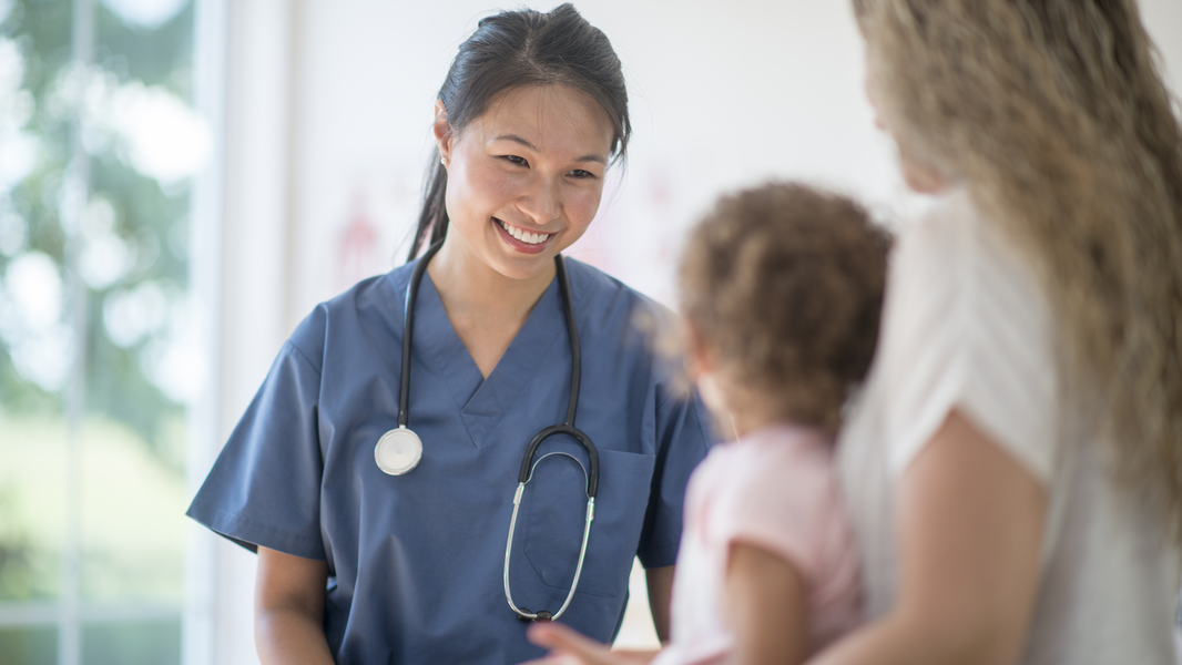 Provider smiles at young girl and her mother.