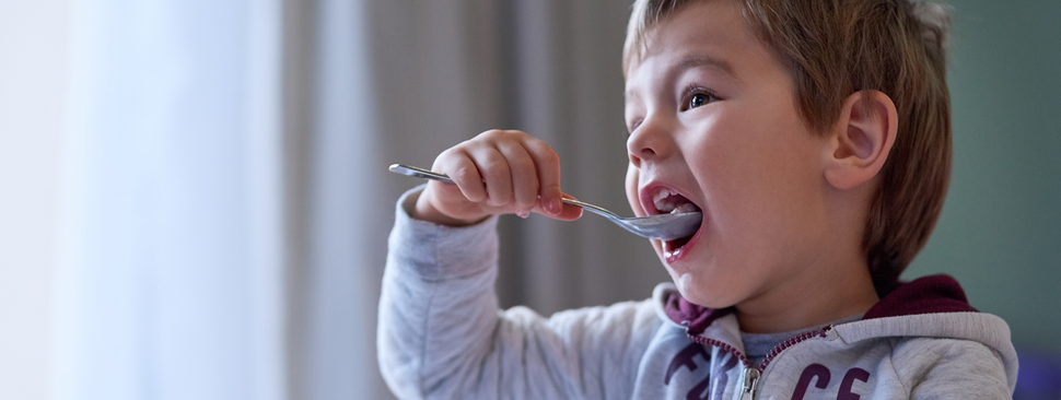 little boy eating breakfast at home