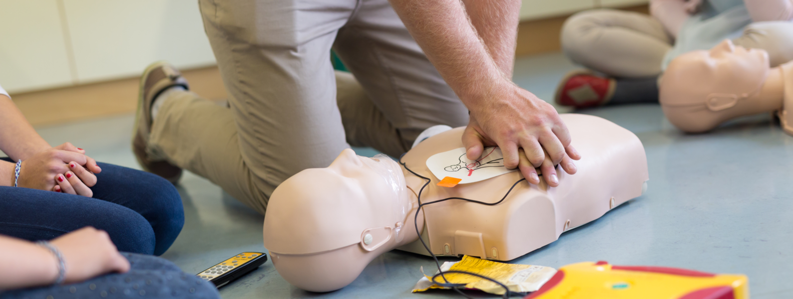 Instructor demonstrating CPR on a dummy.