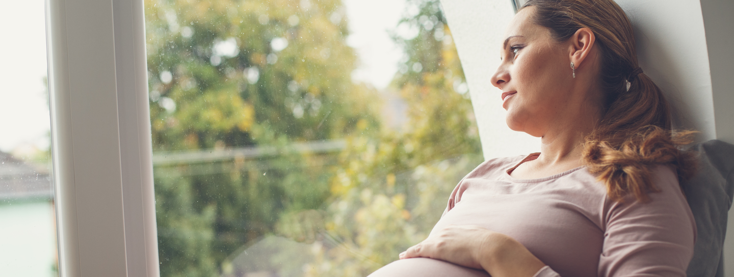 pregnant woman looking out a window