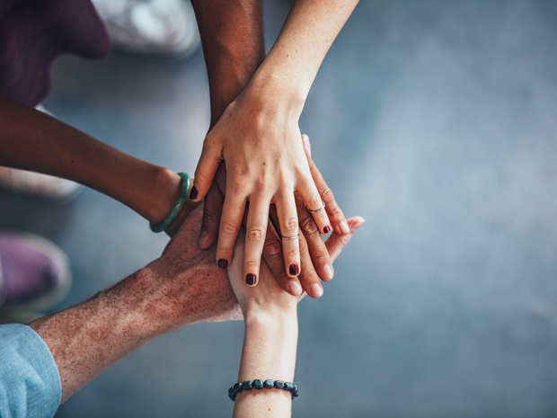 Hands on top of one another in a group.