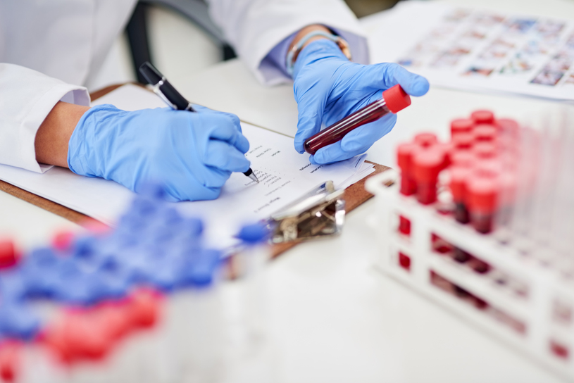Lab technician with test tube and clipboard