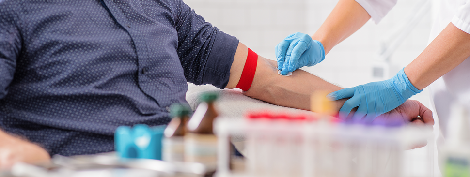 A man holds his arm out to get his blood drawn