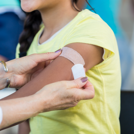 girl gets a band aid after receiving vaccine shot