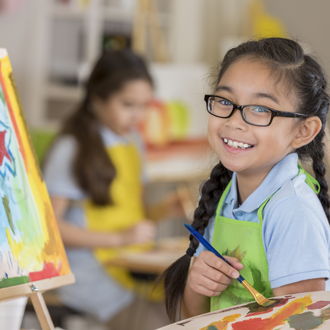 young girl with classes painting a picture