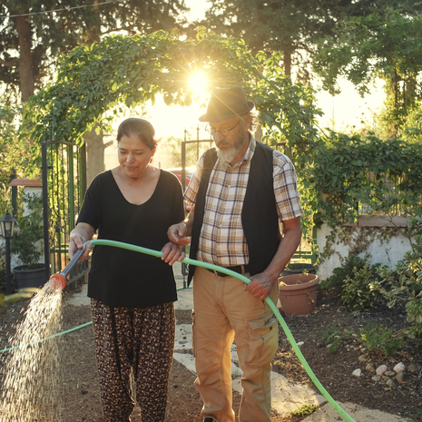 Elderly couple watering a outdoor garden