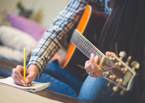 young woman writing music lyrics