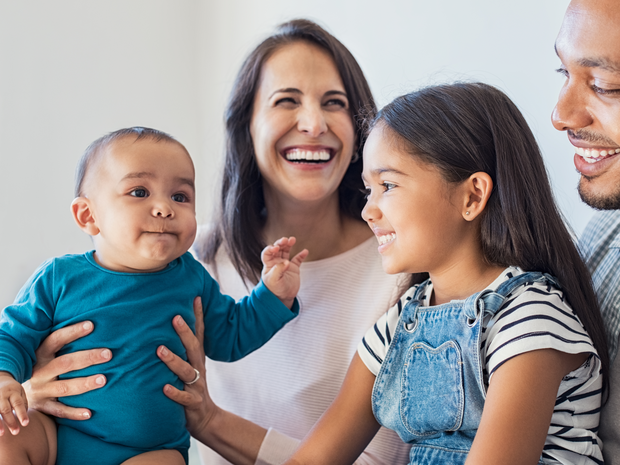 Family of four playing and laughing.