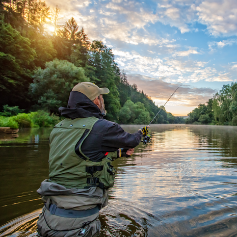 Sport fisherman. Outdoor fishing in river during sunrise.