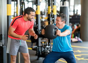 A personal trainer helps a man workout