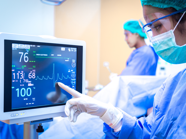 Provider looks at blood pressure on screen.